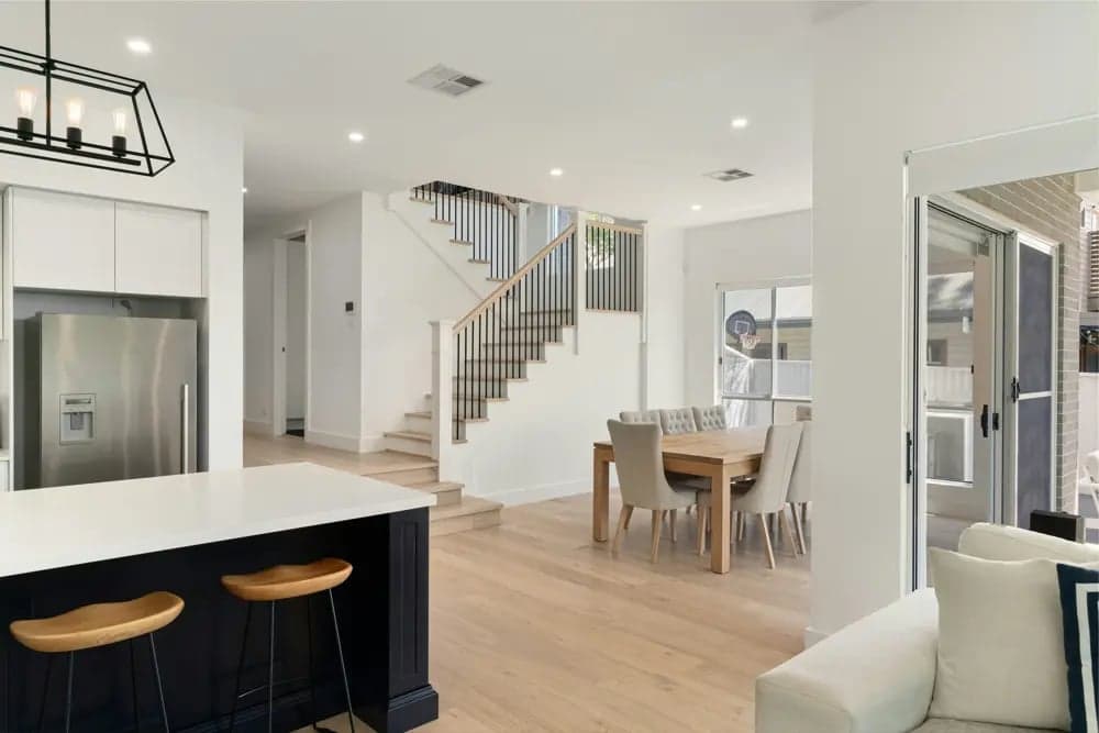 An open-plan kitchen and dining area. In open layouts, consider placing the fridge at the end or outer corner of the kitchen so that someone grabbing a snack doesn't interrupt the cook's main work zone
